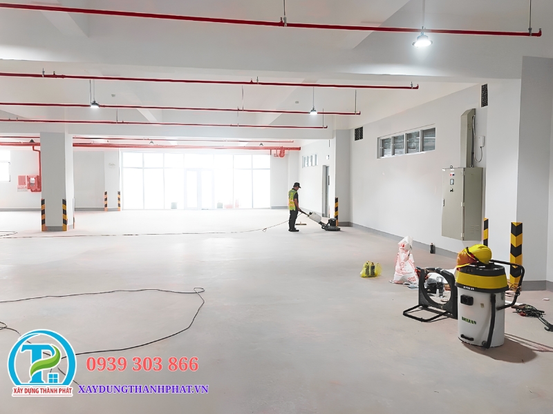 thợ kỹ thuật tiến hành quy trình mài sàn bê tông nhám bằng máy mài sàn công nghiệp cỡ lớn